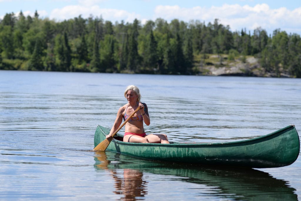 Online fitness in Kenora can include paddling a canoe across a lake.